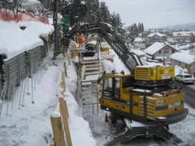 Gravearbeid med gravemaskin i snø