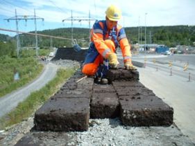 Person i arbeidklær i arbeid ved vei